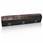 Boîte porte-encens en bois noir fermée, arborant trois incrustations dorées du symbole Om, avec un couvercle finement ajouré de motifs floraux, sur fond blanc.