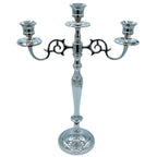 Un candélabre à 3 branches en métal argenté brillant, arborant un style classique avec des volutes décoratives et un pied élancé, présenté sur un fond blanc.