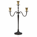 Un candélabre à 3 branches au style raffiné, combinant un corps en métal anthracite foncé et des réceptacles dorés, présenté sur un fond blanc avec un léger reflet.