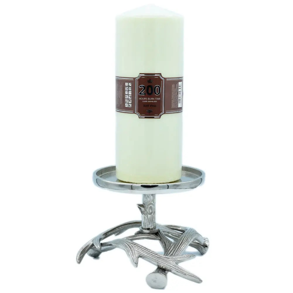 Un bougeoir en métal argenté avec un socle en forme de bois de cerf, supportant une large bougie pilier de couleur crème, présenté sur un fond blanc.