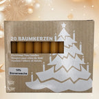 Boîte en carton contenant 20 bougies pour arbre de Noël composées à 10% de cire d'abeille, laissant apparaître les bougies à travers une fenêtre rectangulaire, décorée d'un motif de sapin blanc avec des bougies allumées, sur un arrière-plan festif lumineux.