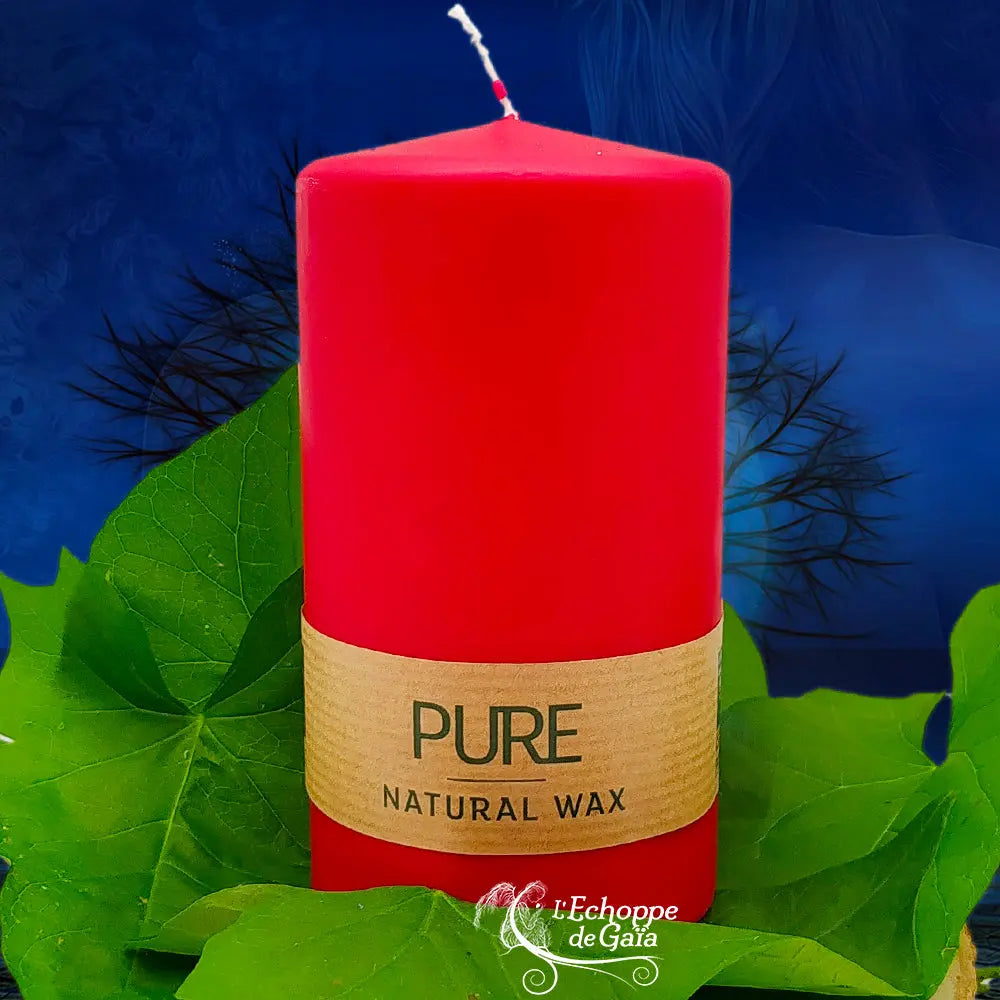 Bougie pilier rouge « PURE » en cire naturelle, étiquette beige, posée sur des feuilles vertes (L’Echoppe de Gaïa).