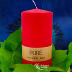 Bougie pilier rouge « PURE » en cire naturelle, étiquette beige, posée sur des feuilles vertes (L’Echoppe de Gaïa).