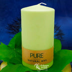 Bougie pilier vert tendre « PURE » en cire naturelle, étiquette beige, posée sur des feuilles vertes (L’Echoppe de Gaïa).