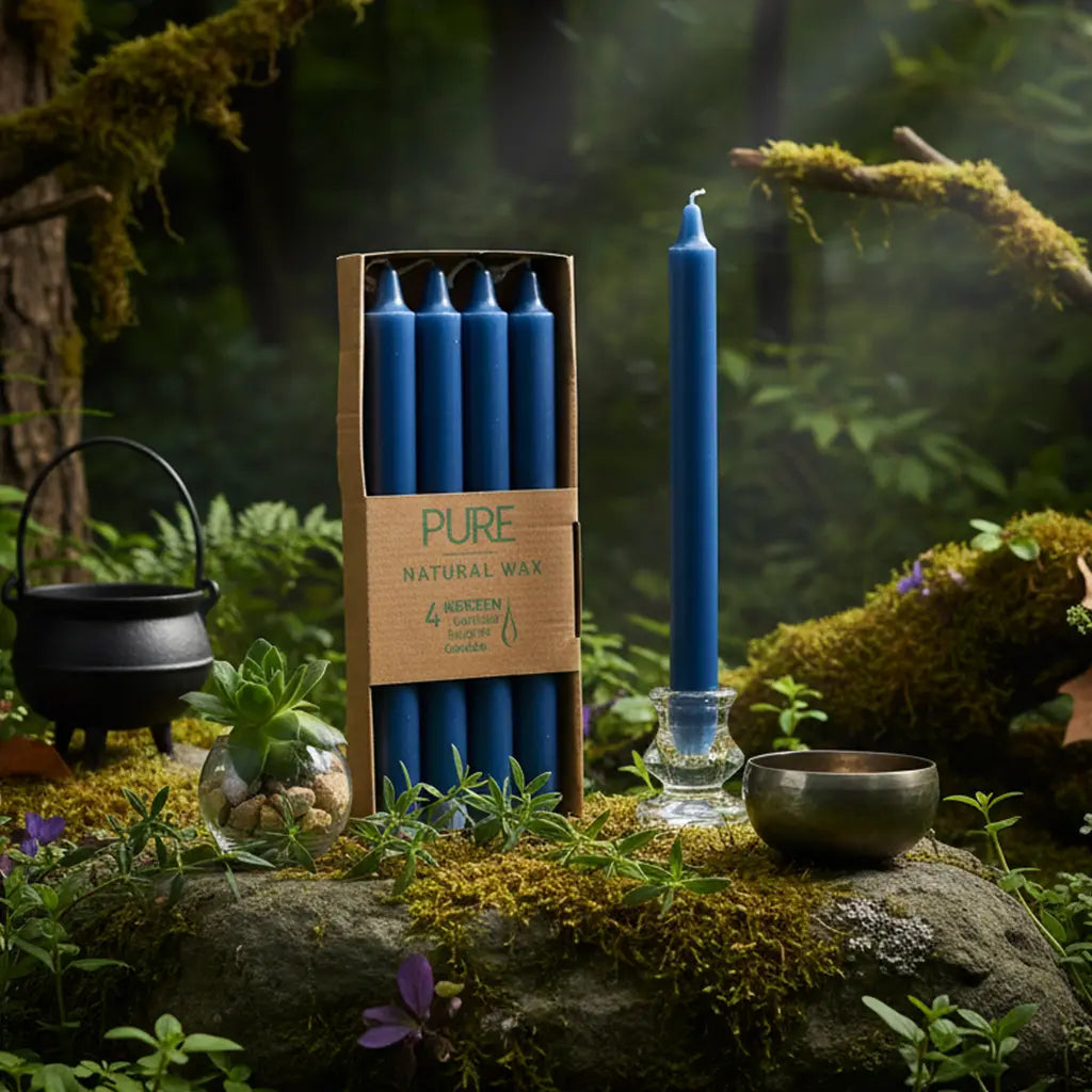 Boîte de 4 bougies longues bleu nuit Pure Candle posée verticalement sur un rocher moussu en forêt, entourée de cristaux et d'un bol chantant pour un rituel naturel.