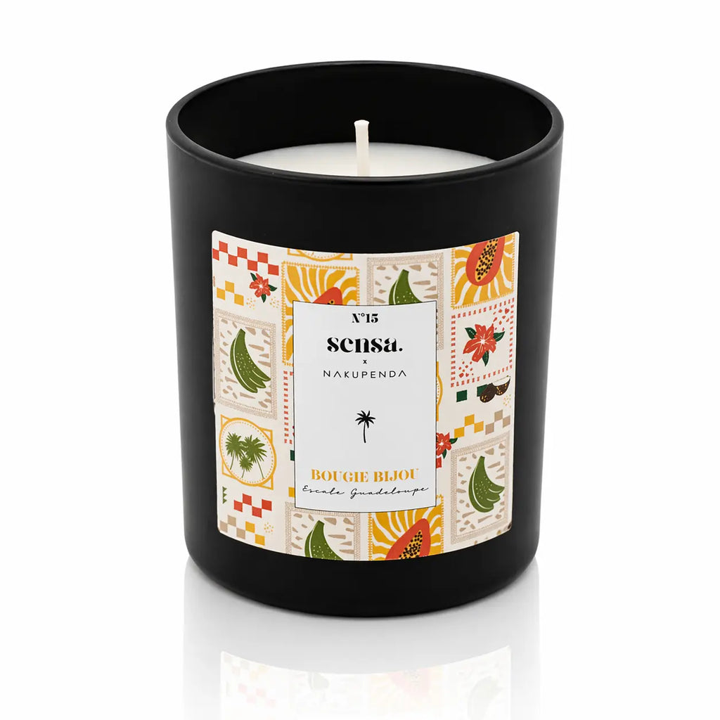 Bougie bijou Sensa x Nakupenda n°15 Escale Guadeloupe dans un pot noir mat avec étiquette motifs fruits exotiques.