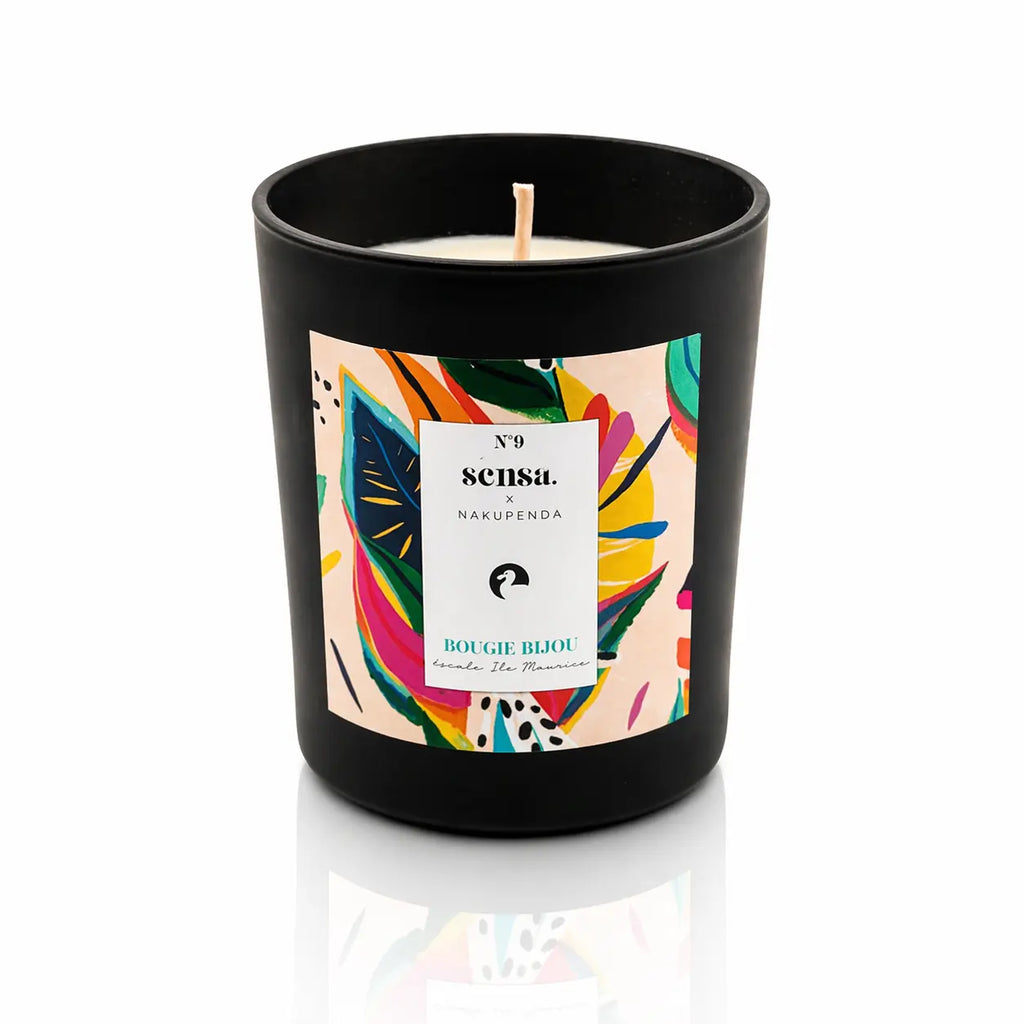 Bougie bijou Sensa x Nakupenda n°9 Escale Île Maurice dans un pot noir mat avec étiquette pop multicolore.