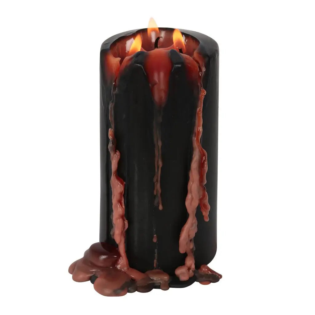 Une bougie pilier noire à trois mèches en cours de combustion, laissant s'écouler d'épaisses coulées de cire rouge contrastantes sur ses parois, présentée sur un fond blanc.