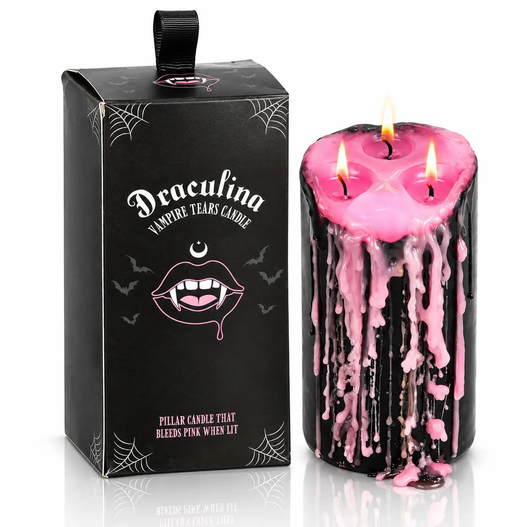 Bougie pilier Draculina Vampire Tears Candle à 3 mèches qui pleure de la cire rose, présentée à côté de sa boîte noire illustrée, sur fond blanc.