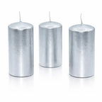 Un lot de trois bougies piliers métallisées argentées, de forme cylindrique, présentées debout sur un fond blanc avec un reflet à leur base.