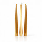 Un lot de trois bougies flambeaux métallisées dorées, de forme effilée et élégante, présentées debout sur un fond blanc avec un léger reflet à leur base.