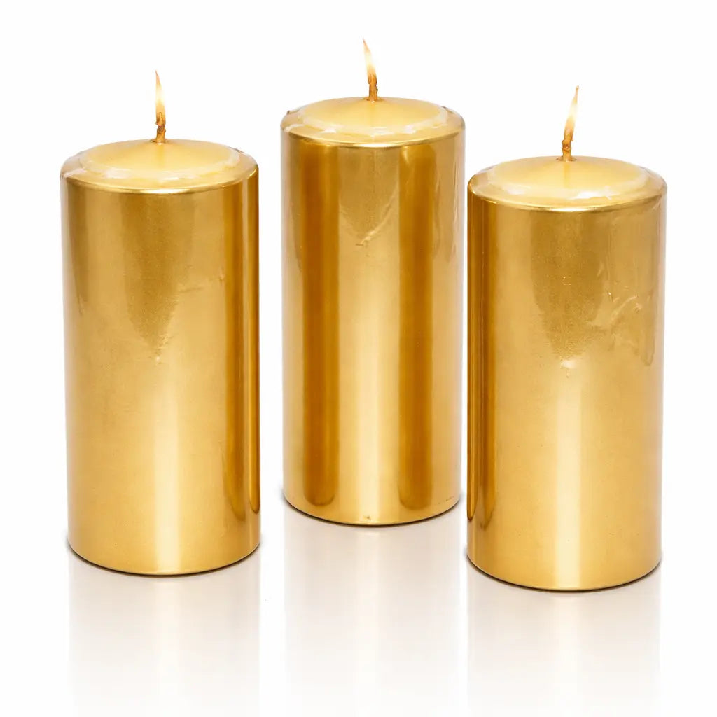 Un lot de trois bougies piliers métallisées dorées, de forme cylindrique, présentées debout sur un fond blanc avec un léger reflet à leur base.