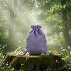 Bourse en toile de jute Mauve - 15 x 12 cm posée sur une souche pour ranger pendules et améthystes.