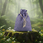 Bourse en toile de jute Mauve - 20 x 14 cm posée sur une souche moussue dans une forêt enchantée.