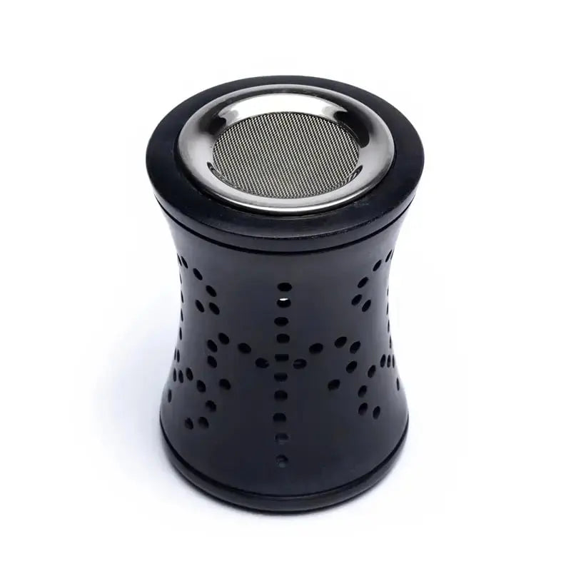 Brûle-encens en stéatite noire (forme “sablier”) vu de face : motifs ajourés en points sur les côtés, et en haut une bague métallique brillante avec une grille fine (tamis) intégrée, sur fond blanc.