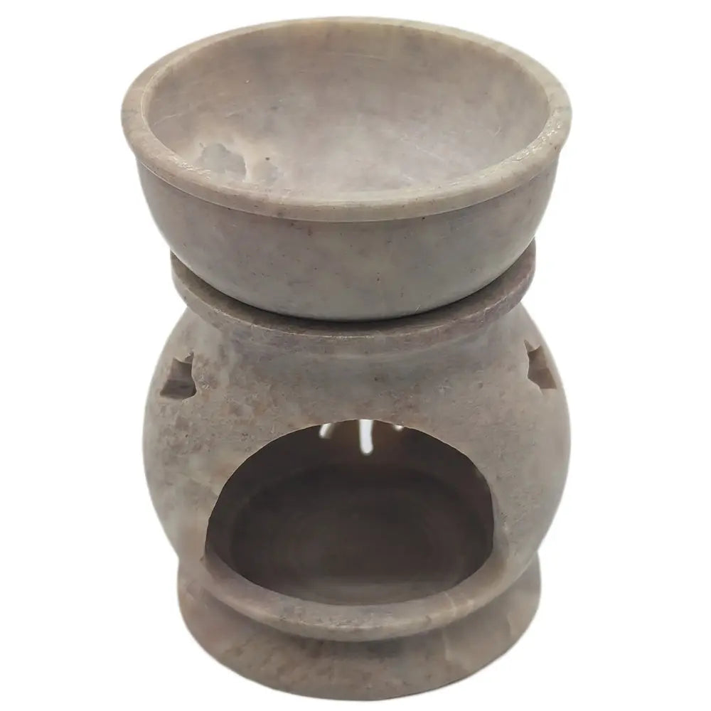 Brûle-encens en pierre stéatite claire, forme ventrue sur base ronde, ouverture ronde et deux ajours sur les côtés, fond blanc.