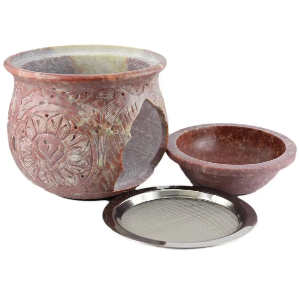 Brûle-encens en stéatite marbrée rouge et crème, motifs floraux gravés, bol amovible et tamis métallique posés devant, fond blanc.
