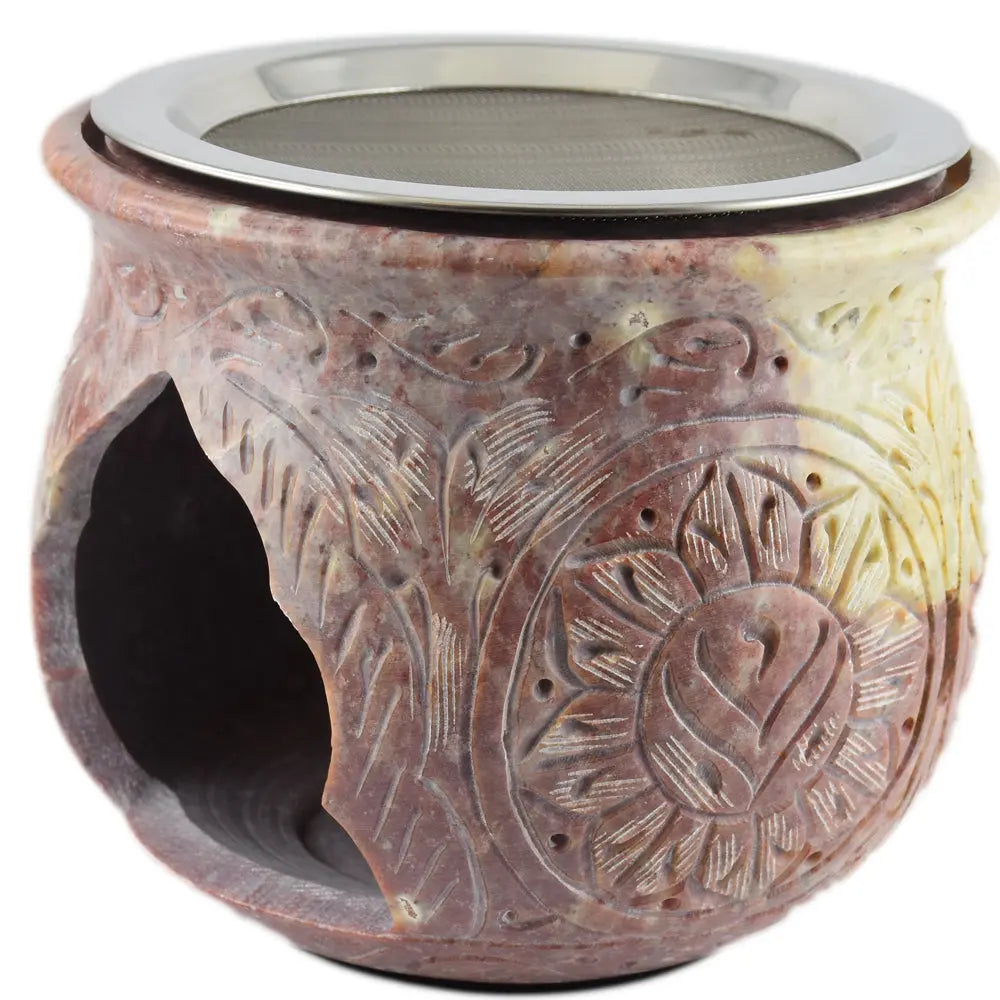 Brûle-encens en stéatite marbrée rouge et crème, motifs floraux gravés, ouverture latérale et tamis métallique sur le dessus, fond blanc.