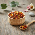 Coupelle en bois remplie de grains d’encens à la cannelle orangés avec petite cuillère sur table en bois.
