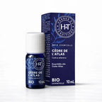 Un flacon de 10 ml et son emballage d'huile essentielle de Cèdre de l'Atlas (Bio) de la marque Herbes & Traditions, présentés sur un fond blanc épuré.