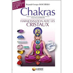 Livre Chakras de R.G. Boschiero : femme en méditation avec symboles des chakras et cristaux colorés sur fond blanc.