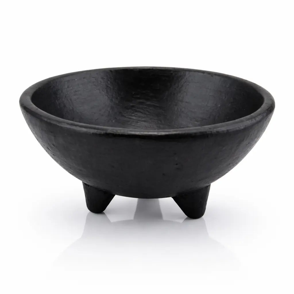 Bol trépied noir mat avec une texture rugueuse et trois pieds coniques sur un fond blanc avec reflet.
