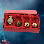 Coffret rouge contenant un ensemble de pendules de type Séphoroton, incluant un modèle monté avec une sphère en bois clair, ainsi que trois sphères interchangeables : une en œil-de-tigre et deux en métal (doré et cuivré).