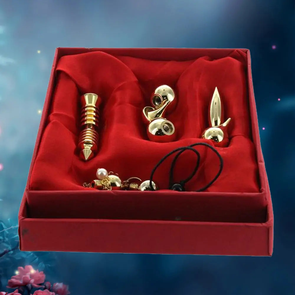 Coffret de présentation rouge contenant un ensemble de trois pendules en métal doré disposés sur un tissu satiné : un modèle égyptien (Thot) strié, un modèle goutte d'eau et un modèle conique effilé, accompagnés de leurs chaînes de suspension.