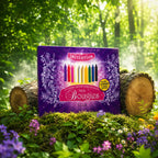 Livre Le Coffret des Pouvoirs Magiques des Bougies sur mousse sacrée au pied d'un arbre, entouré de fleurs violettes sous des rayons de soleil magiques.