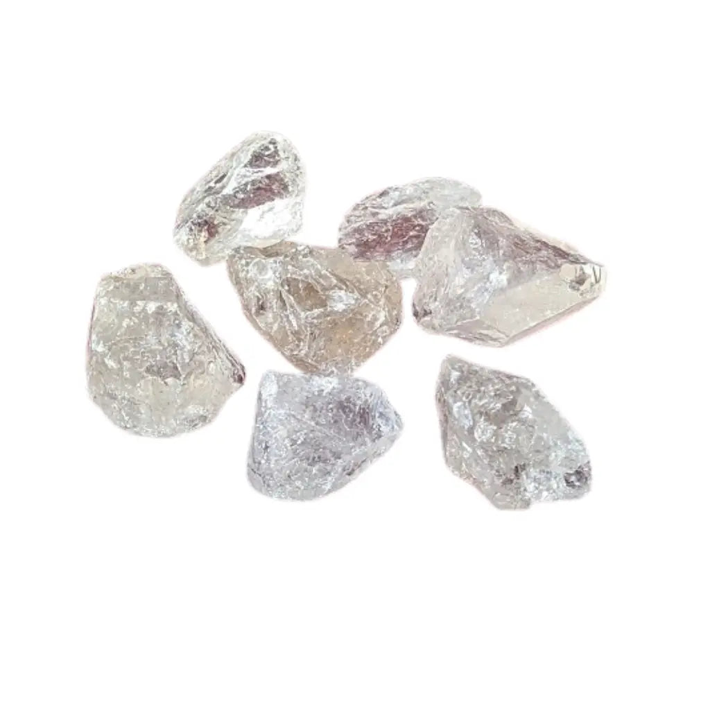 Sept fragments de cristal de roche brut translucides et facettés, aux éclats vitreux naturels, regroupés sur un fond blanc uni.