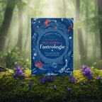 Livre bleu Découvrir les Pouvoirs de L'Astrologie de Theresa Cheung posé sur une souche moussue, illustré de signes du zodiaque et d'étoiles scintillantes.