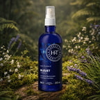 Flacon bleu spray d'Eau Florale de Bleuet Herbes et Traditions posé dans un sous-bois enchanteur avec mousses et fleurs de lavande.
