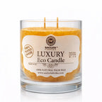 Une bougie parfumée artisanale orange « Luxury Eco Candle » de la marque Saules Fabrika, présentée dans un large pot en verre avec deux mèches en coton, sur un fond blanc.