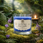 Bougie parfumée Eco Candle 30h - Ange de couleur bleue en verre transparent sur un tapis de mousse forestière.
