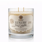 Une bougie parfumée artisanale beige (gingembre) « Luxury Eco Candle » de la marque Saules Fabrika, présentée dans un large pot en verre avec deux mèches en coton, sur un fond blanc.
