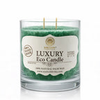 Une bougie parfumée artisanale verte « Luxury Eco Candle » de la marque Saules Fabrika, présentée dans un large pot en verre avec deux mèches en coton, sur un fond blanc.