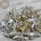 Gros plan sur un encens astrologique Gémeaux, mélange de sels, résines dorées et fleurs de lavande séchées sur fond bois clair.