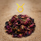 Gros plan d’encens astrologique Taureau, mélange de pétales de rose séchés et résine sombre sur fond sable avec symbole du Taureau.