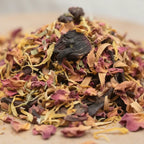 Gros plan sur un mélange d’encens pour le chakra sacré, composé de pétales séchés colorés et de morceaux de fleurs foncés.