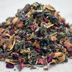 Gros plan sur un mélange d’encens pour le chakra du cœur, composé d’herbes vertes et de pétales colorés séchés.