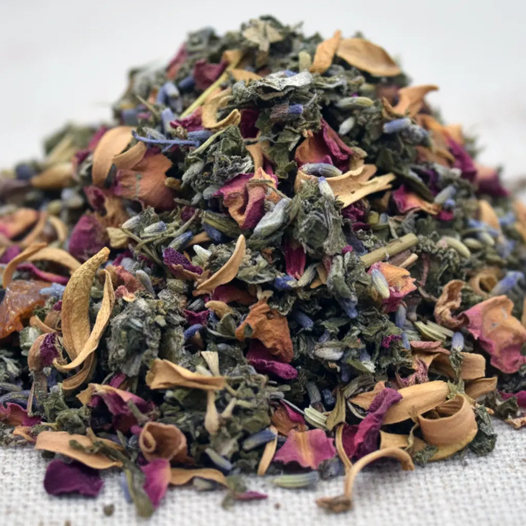 Gros plan sur un mélange d’encens pour le chakra du cœur, composé d’herbes vertes et de pétales colorés séchés.