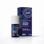 Un flacon de 5 ml d'huile essentielle d'encens oliban bio de la marque Herbes & Traditions, accompagné de son étui en carton bleu foncé assorti, présenté sur un fond blanc.