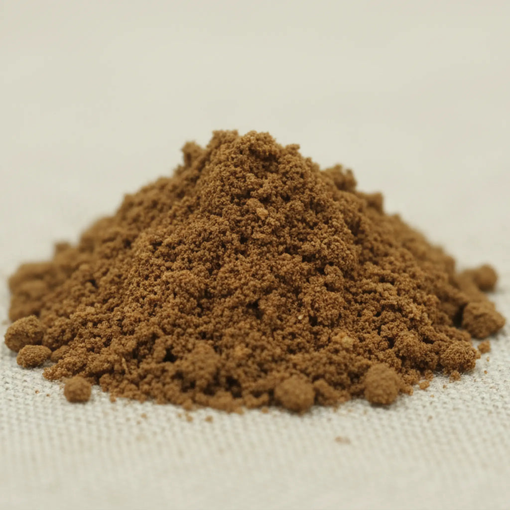 Tas de poudre d’encens nard de l’Himalaya brun à grain fin sur tissu clair.
