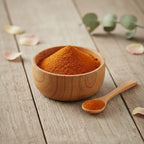 Coupelle en bois remplie de poudre de santal rouge orangé fine avec cuillère sur table en bois.