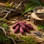 Bâtons d’encens roses disposés sur table en bois, avec porte-encens en céramique, mousse, fougères et brins de lavande.
