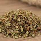 Mélange d'encens Succès composé de feuilles vertes concassées, de résines brunes et de fragments d'écorce.