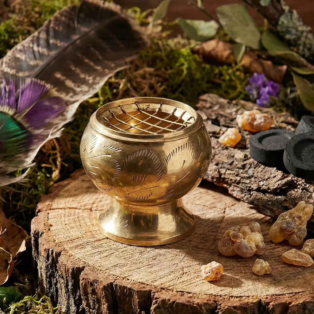 Brûle Encens laiton doré avec grille sur le dessus posé sur une souche de bois avec des résines.