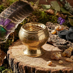 Brûle Encens laiton doré avec grille sur le dessus posé sur une souche de bois avec des résines.