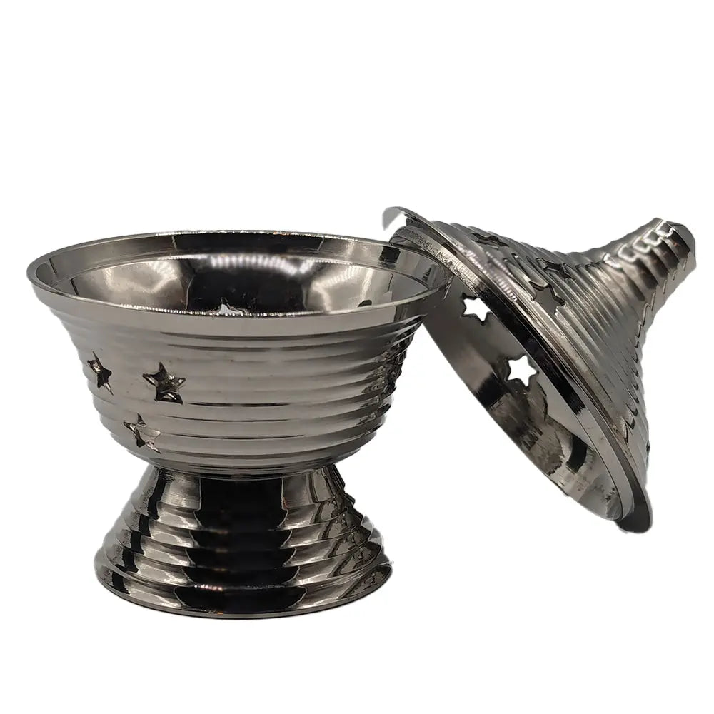 Encensoir avec couvercle en métal couleur argent, bol strié avec étoiles découpées, dôme conique ajouré à étoiles, présenté ouvert, fond blanc.