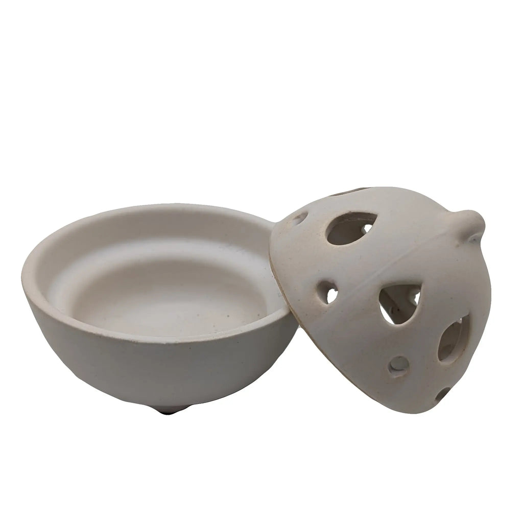 Brûle-encens en céramique blanche avec bol rond et couvercle perforé à ouvertures triangulaires, posé sur fond blanc.